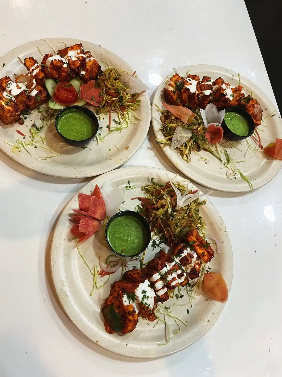 Three plates of tandoori paneer tikka with salad and mint chutney at Shivansh Food Park