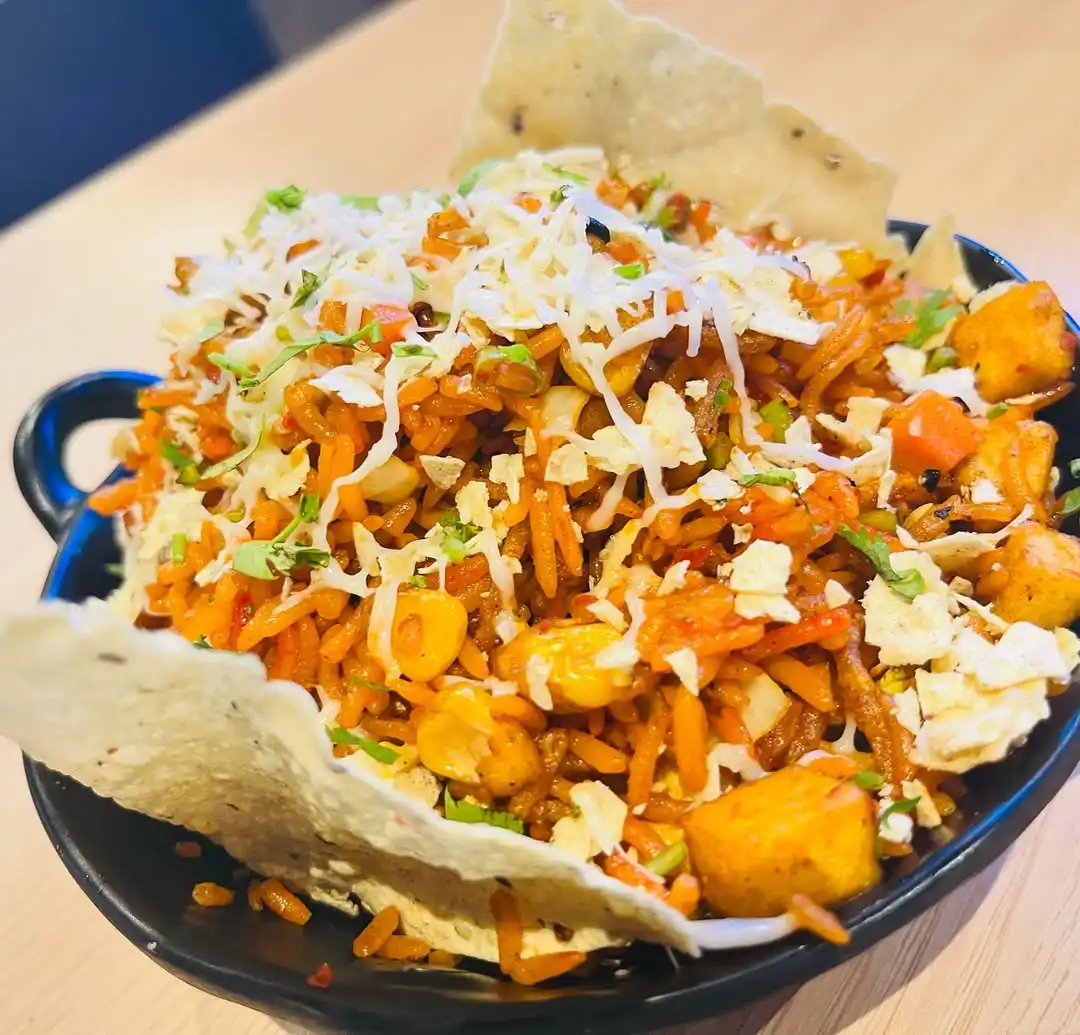 Street-style chaat bowl topped with sev, cheese and papdi at Shivansh Food Park