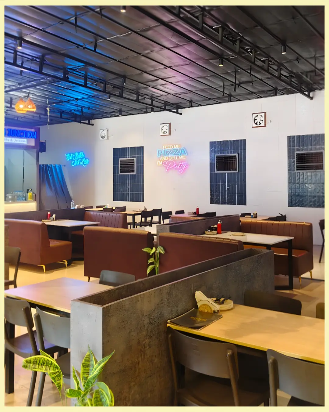 Neon lit dining hall with plush booths at Shivansh Food Park Dhamtari